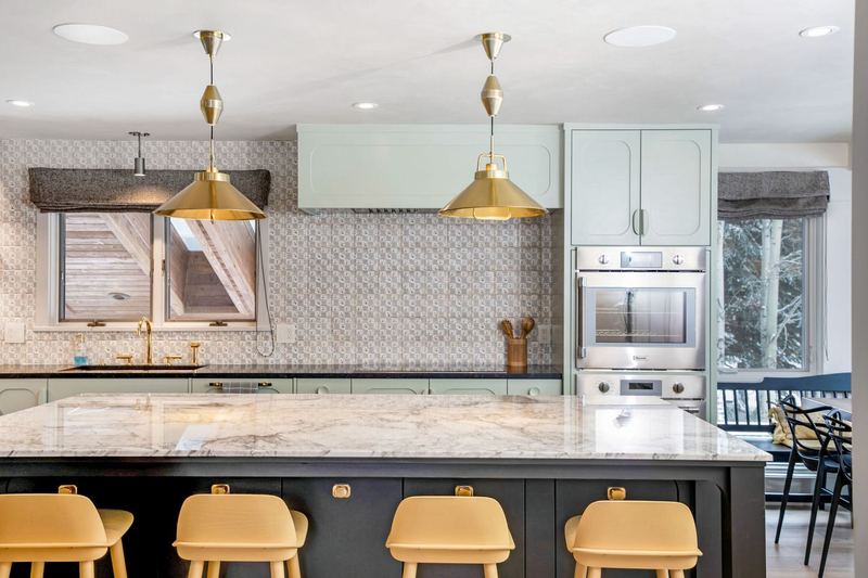 Kitchen: Painted cabinetry, marble island, brass pendants